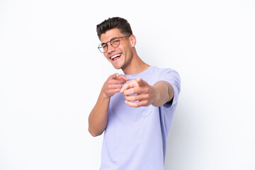 Young caucasian man isolated on white background surprised and pointing front