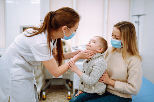 The Pediatrician Examines The Sick Boy. A Child With His Mother In The Office Of A Pediatrician Or Otolaryngologist.