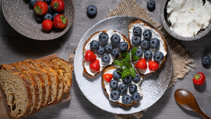 Fresh breakfast with blueberry, strawberry and ricotta rye sandwiches