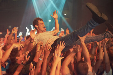 Music, party and crowd surfing with man at concert for rock, celebration and festival. Energy,...