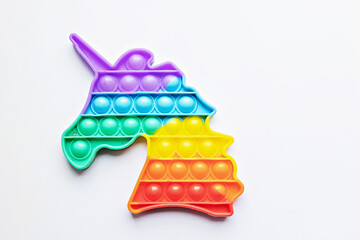 Pop it fidget toy. Multi-colored anti-stress toy with a wing shape on a white background