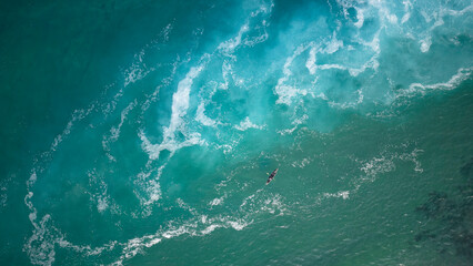 Top view  of a man paddles a kayak in raging sea water