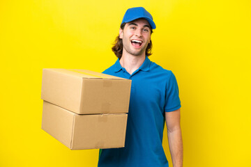 Delivery handsome man isolated on yellow background with surprise facial expression