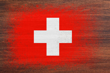 Flag of Switzerland. Flag is painted on a wooden surface. Wooden background. Plywood surface. Copy space. Textured background