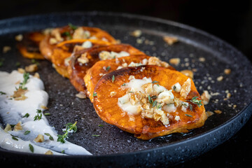 Baked sweet potato with blue cheese, sliced and sprinkled with honey.