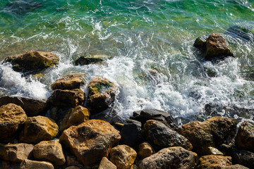 A top view of waves breaking between rocks