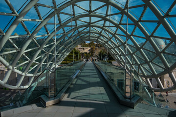 Tbilisi, GEORGIA : 05 - 10 - 2022 : The Bridge of Peace is a bow-shaped pedestrian bridge over the Kura River in old Tbilisi, Georgia