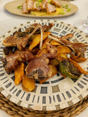 lamb chops with french fries on white plate with green chili peppers. Castilian typical dish in Spain