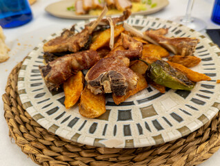 lamb chops with french fries on white plate with green chili peppers. Castilian typical dish in Spain