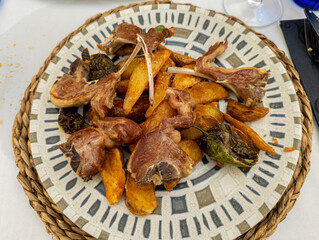 lamb chops with french fries on white plate with green chili peppers. Castilian typical dish in Spain