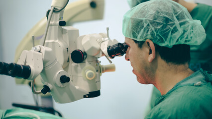 Eye surgery. A patient and surgeon in the operating room during ophthalmic surgery. Patient under...