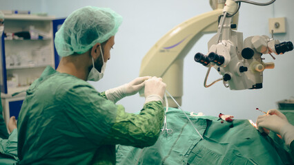 Eye surgery. A patient and surgeon in the operating room during ophthalmic surgery. Patient under surgical microscope. 