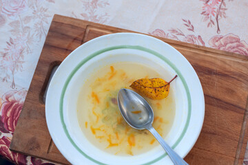   A bowl of half-eaten soup and shriveled autumn oysterfish floating in the soup.