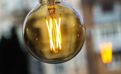 The yellow incandescent bulb is on during the day