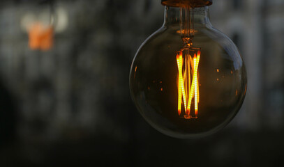The yellow incandescent bulb is on during the day