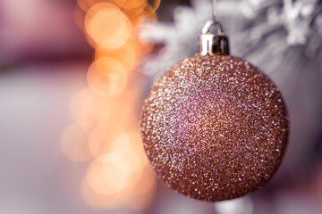 Gold glitter Christmas tree glass ball bauble decoration, golden bokeh, snowy background
