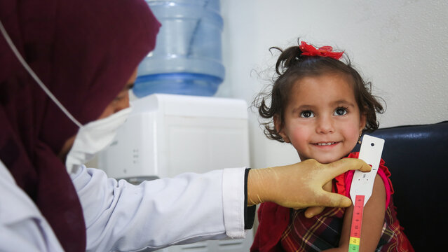 Doctor examines child malnutrition. Measuring malnutrition using strap MUAC mid-upper-arm-circumference.	
