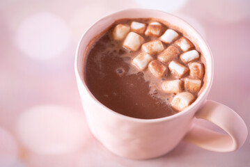 Hot chocolate with marshmallows on top in a pink cup with copy space