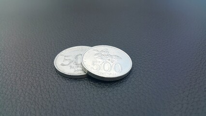 Close-up of two coins on the dashboard of the car. Five hundred rupiah coins.