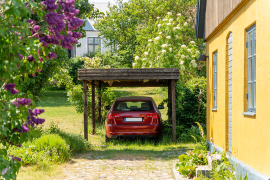 Image of Swedish summer house with wooden carport in the garden