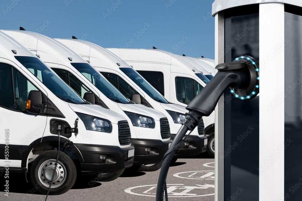 Sticker Electric vehicles charging station on a background of a row of vans. Green transportation concept	