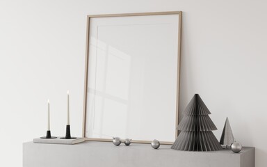 An empty frame on a concrete fireplace with a Christmas stylish decor, a grey paper tree, Christmas toys, candles in a candlestick. Mockup frame for christmas	