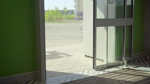 Automatic non-contact doors open and close. Close-up. Daylight sunlight