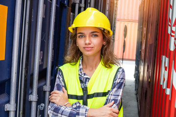 Portrait of confident young caucasian female engineer with container background.