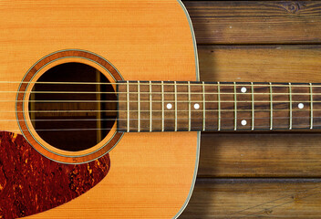 Obraz premium acoustic guitar on wooden surface in background 
