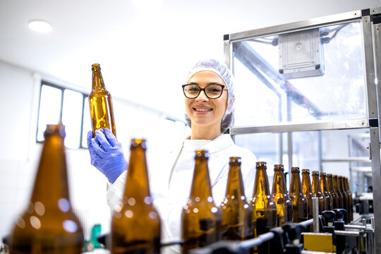 Portrait of female factory supervisor controlling beer production in alcohol beverage bottling plant.