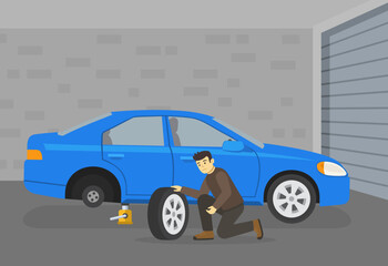Car driving tips and rules. Young male character sits down and changes the flat rear tire in his garage. Side view. Flat vector illustration template.