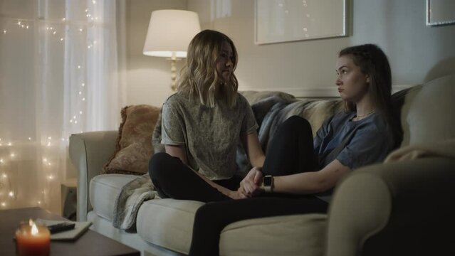 Girls hanging out and talking on sofa at night / Cedar Hills, Utah, United States