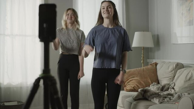 Tilt up to girls recording dance routine on cell phone for social media / Cedar Hills, Utah, United States
