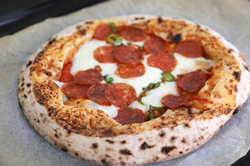 Neapolitan pizza with sausage and jalapeno in the kitchen at home