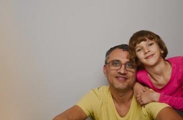 Dad and daughter in the right corner of the photo, both are happy looking at the camera, the left corner is empty