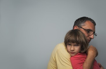Dad hugs and calms his very offended daughter, the left corner is empty