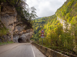 Mountain highway, at the entrance to the tunnel cut into the rock. Beautiful street in a rocky...