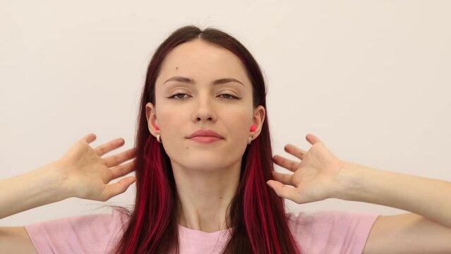 Young pretty woman puts earplugs in her ears, noise protection.