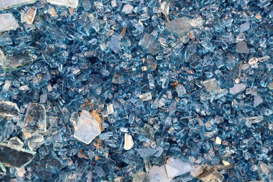 Broken windows, a lot of broken windows at the construction site or building. Shards of laminated blue glass
