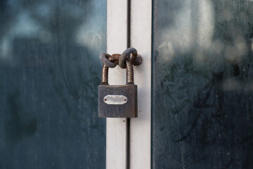 There is a lock on the office door. Rusty chain on glass door and lock on it, bankrupt or closed business concept