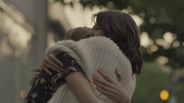 Slow motion close up of happy women hugging outdoors / Provo, Utah, United States