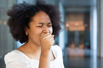 Fototapeta na wymiar allergic sick African woman coughing and having sore throat, concept image of cold flu or covid-19 infection, health care and allergy