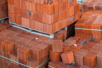 Orange clay block at construction site, Orange hollow brick, in pallet stacked, stretch-wrapped