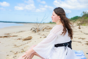 Fototapeta na wymiar 砂浜に座る白人の女の子