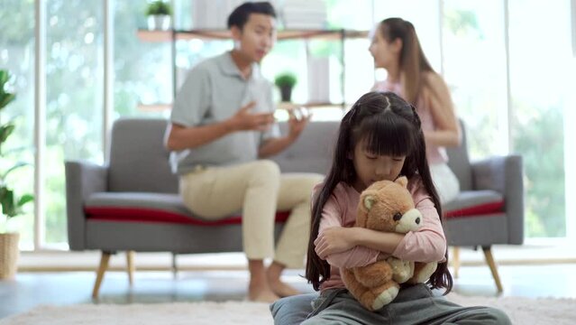 Unhappy family and issue. A little girl crying during her mother and father shouting to each other.