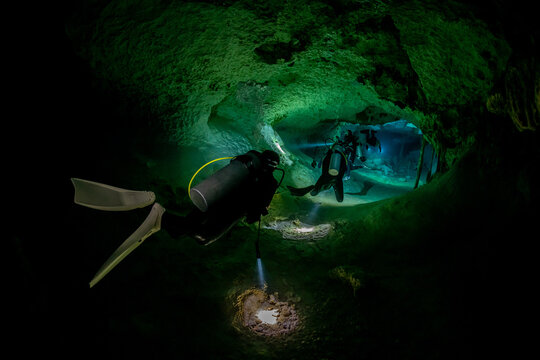cave diver instructor leading a group of divers in a mexican cenote underwater