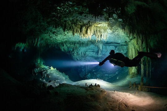 cave diver instructor leading a group of divers in a mexican cenote underwater