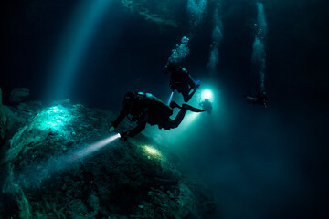 Naklejka na ściany i meble cave diver instructor leading a group of divers in a mexican cenote underwater