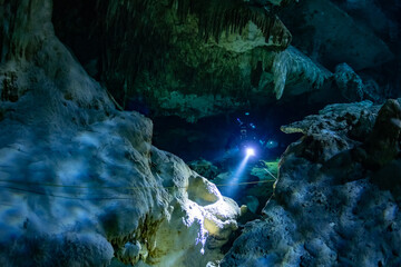 Obraz premium cave diver instructor leading a group of divers in a mexican cenote underwater