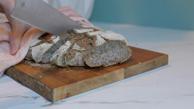 Vertical shot of dark rye wheat bread cutting on wood block
